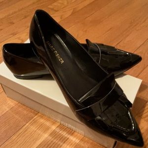 Woman’s black patent leather pointed toe flat.